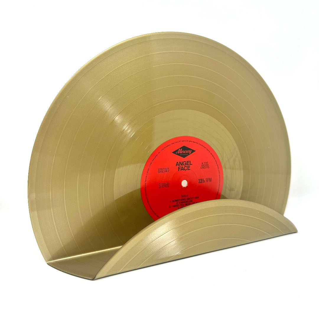 A recycled golden vinyl record used as a wall decor display